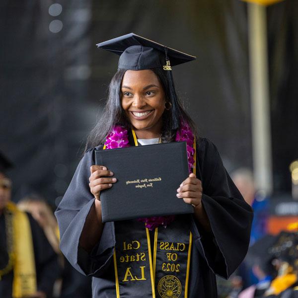 A student holds her diploma at graduation ceremony.